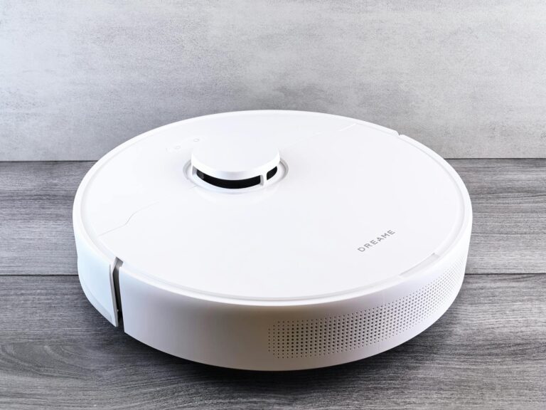 Sleek white robot vacuum cleaner on a wooden floor, perfect for smart home setups.
